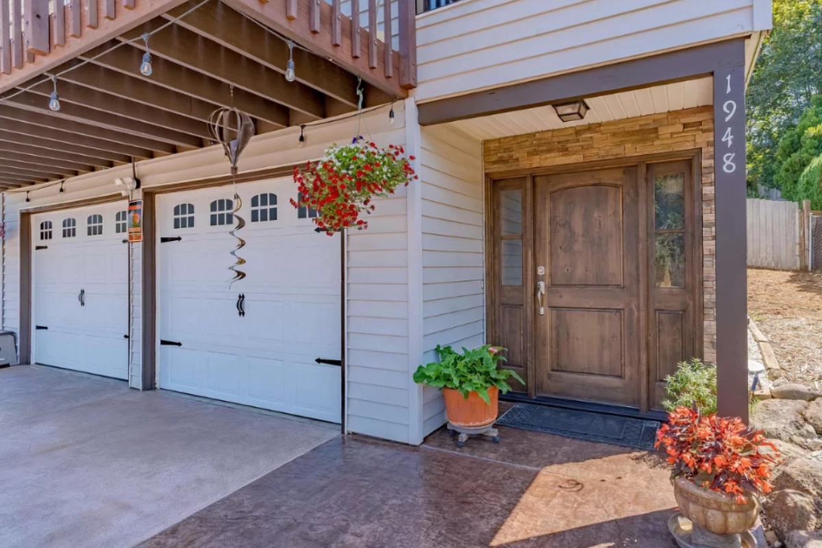 Front entryway and garage featuring two-tone stained concrete in Aztec Brown and Sunset Tan with clean detailing and vibrant curb appeal.