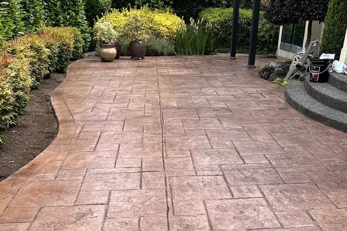 Stamped concrete patio colored with Auburn Antiquing Stain showing uniform, natural reddish-brown tone and matte finish.