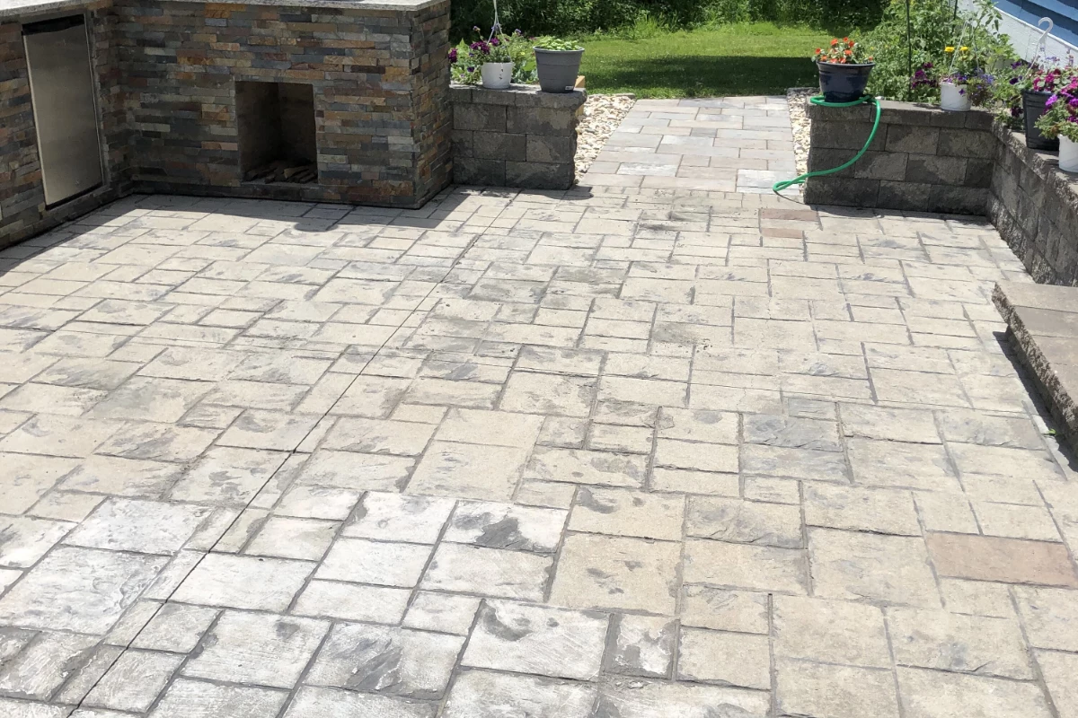 Close-up of worn stamped concrete surface showing discoloration and loss of color