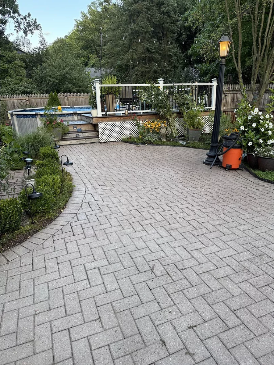 Before photo of faded brick courtyard with light-colored pavers showing signs of aging and wear.
