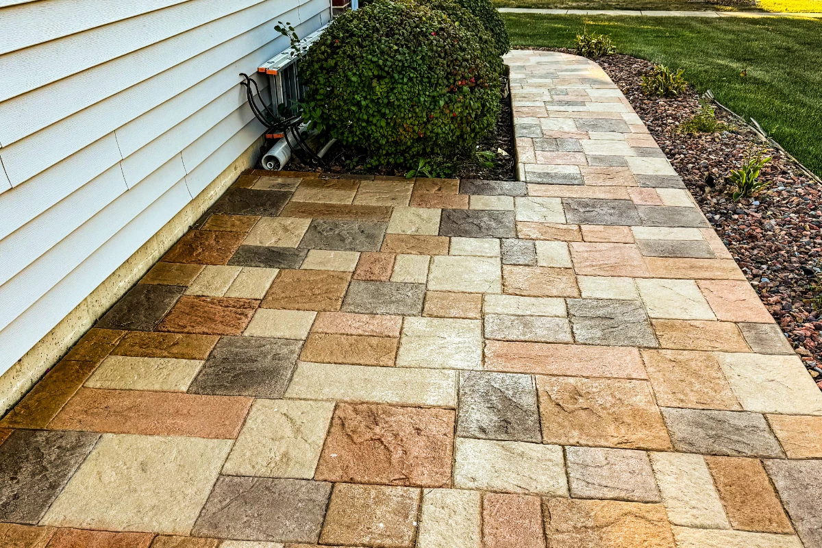 Finished Auburn, Khaki, Terracotta, and Yukon Gold-stained stamped concrete patio with outdoor furniture and glossy EasySeal finish.
