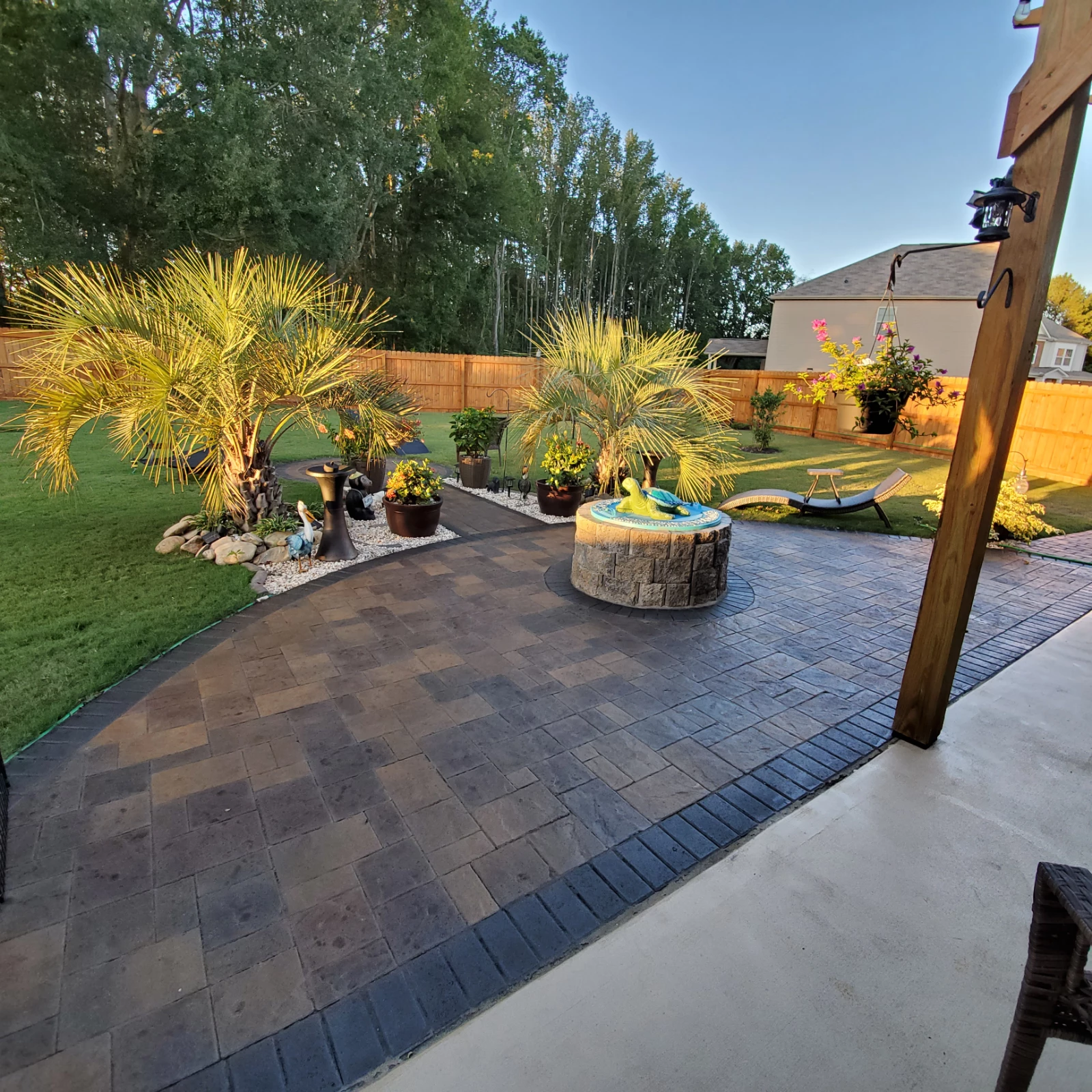 Beautiful landscaped backyard walkway and patio featuring bold paver colors and fresh sealing with Aztec Brown and accents