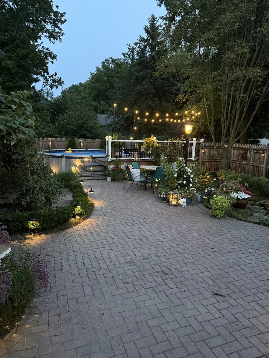 Revitalized brick courtyard stained with Aztec Brown and sealed with a satin finish, surrounded by vibrant landscaping.