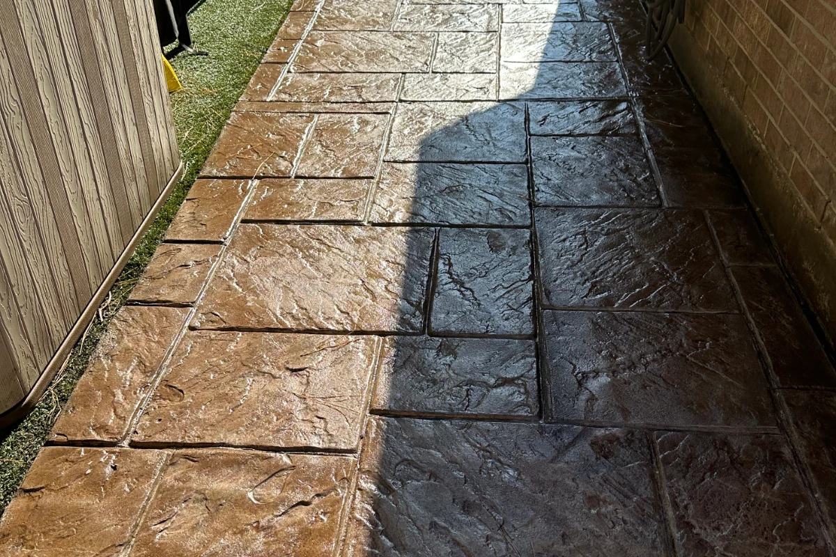 Stamped concrete walkway with rich, warm tones from Aztec Brown Antiquing™ Stain and glossy water-based sealer finish