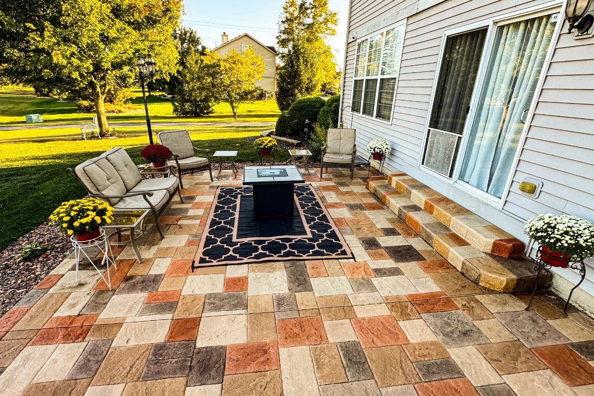Backyard stamped concrete patio stained with Antiquing Auburn, Khaki, Terracotta, and Yukon Gold for a multicolor paver-style finish.