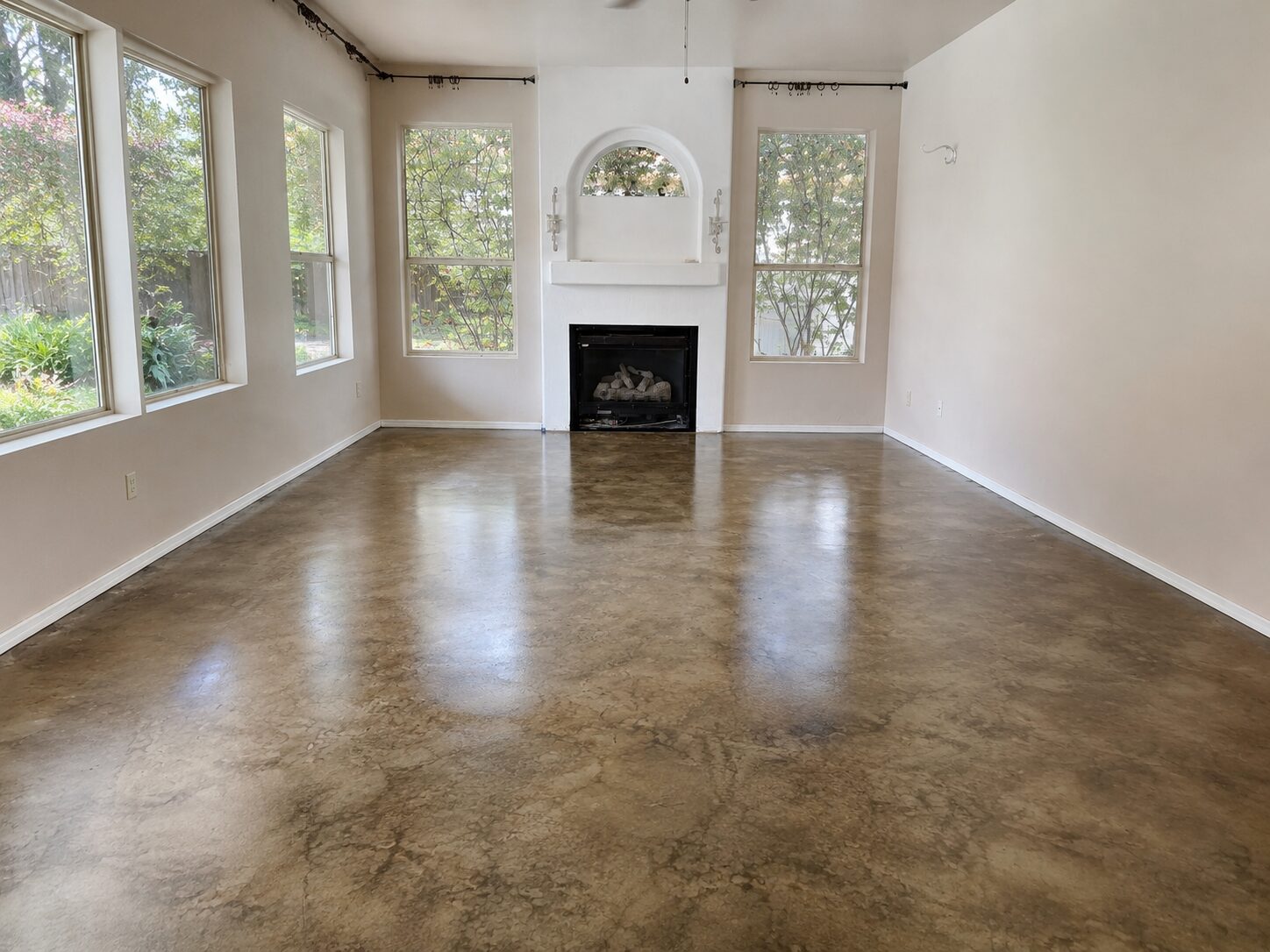 Finished living room with glossy mottled brown ColorWave Stone stained concrete floor sealed with AcquaSeal Satin and ProWax Polish Satin.