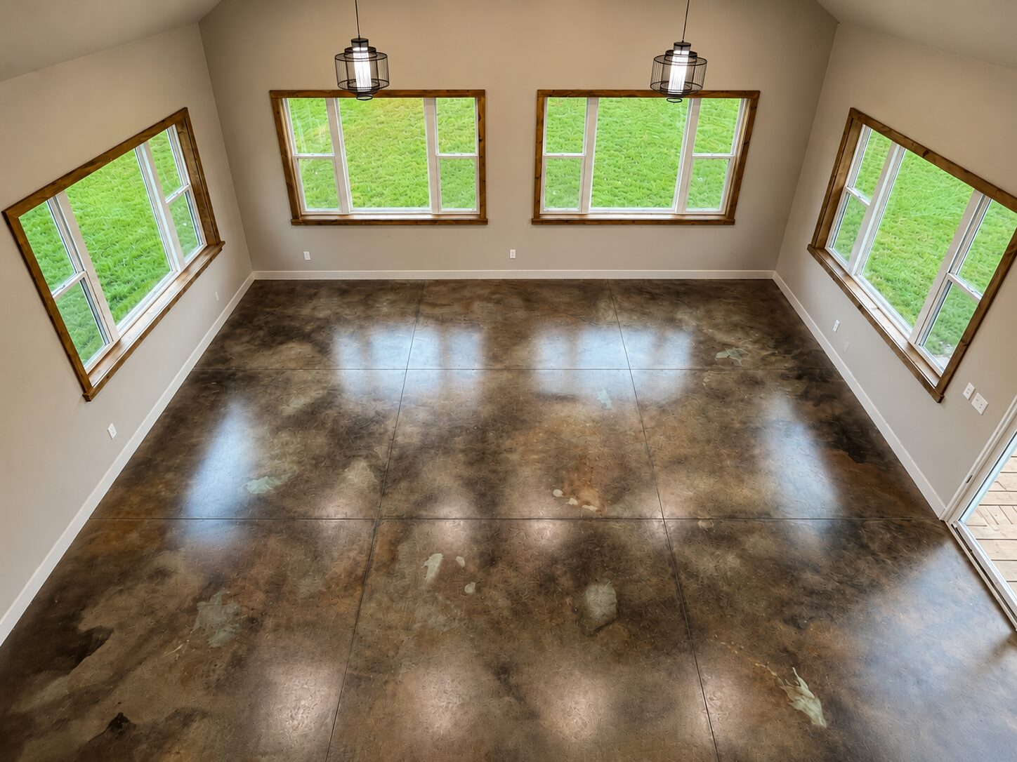 Loft-style room with EverStain Black, Malayan Buff, and Seagrass acid-stained concrete floor, showing a glossy layered marbled finish.