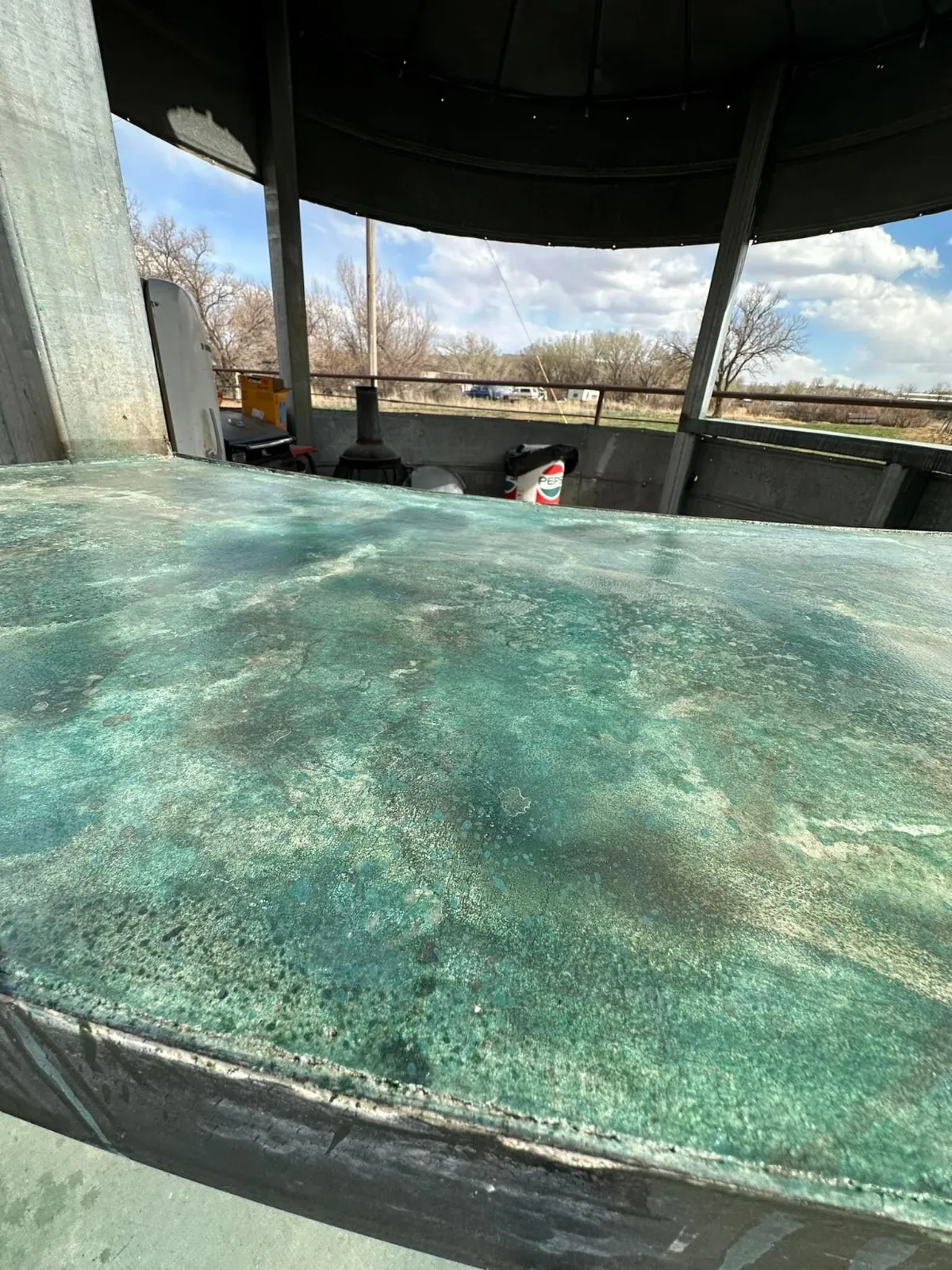 Finished turquoise acid-stained concrete grain-bin bar on a stained patio