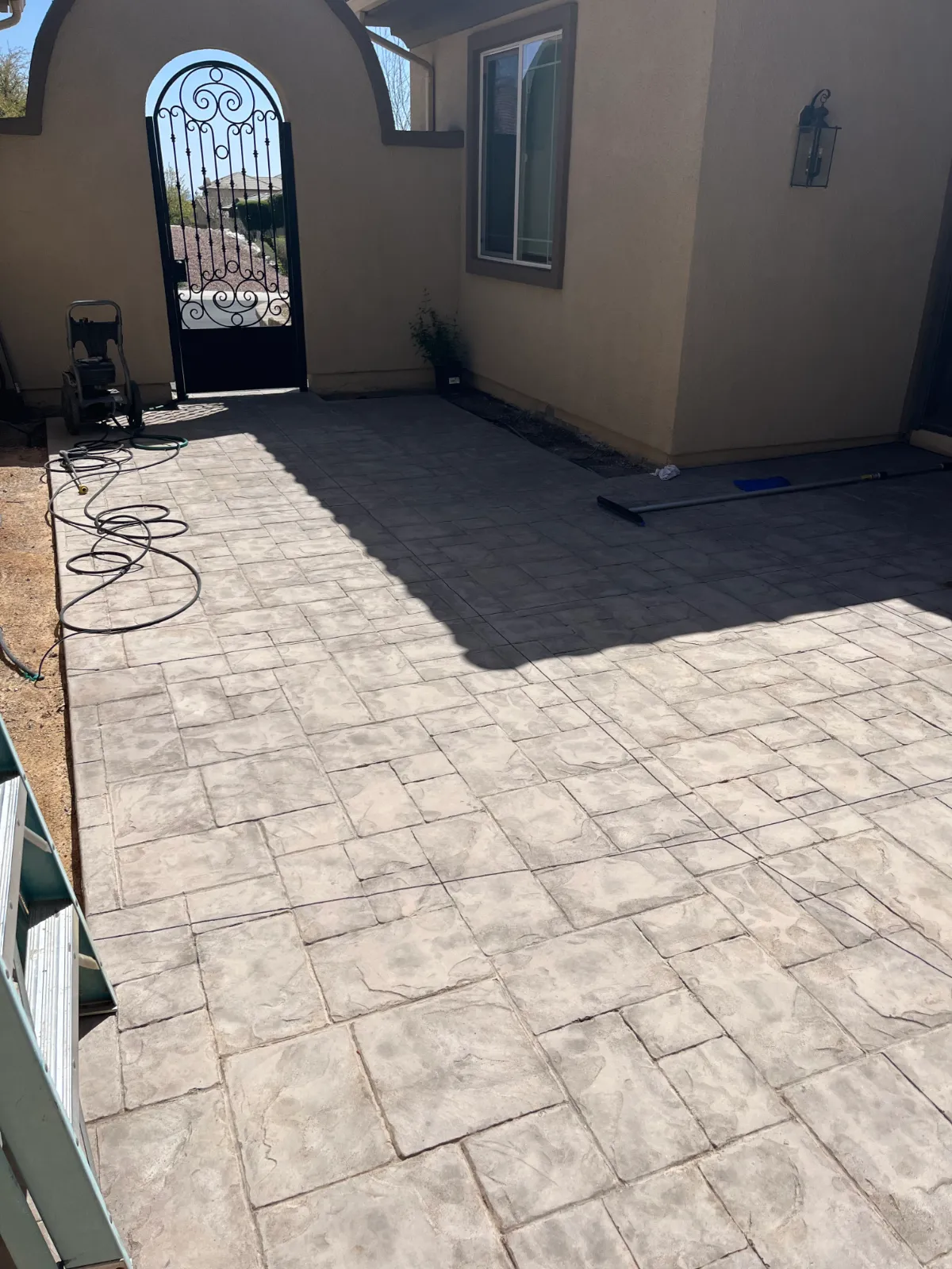 Faded stamped concrete courtyard before applying Tweed Antiquing Stain.