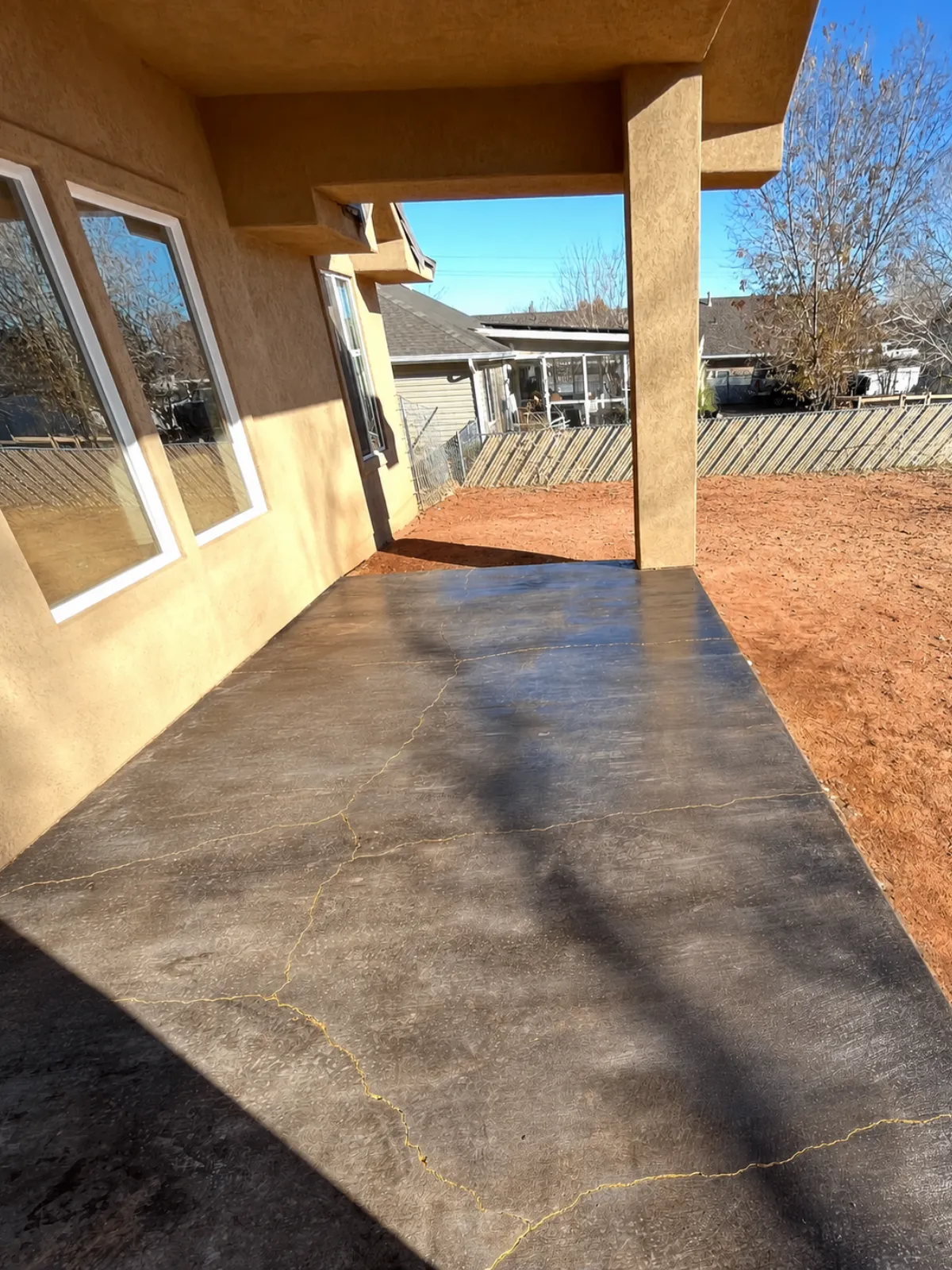 Broom-finish concrete patio transformed with Black Antiquing Stain, gold-painted cracks, and satin acrylic sealer.