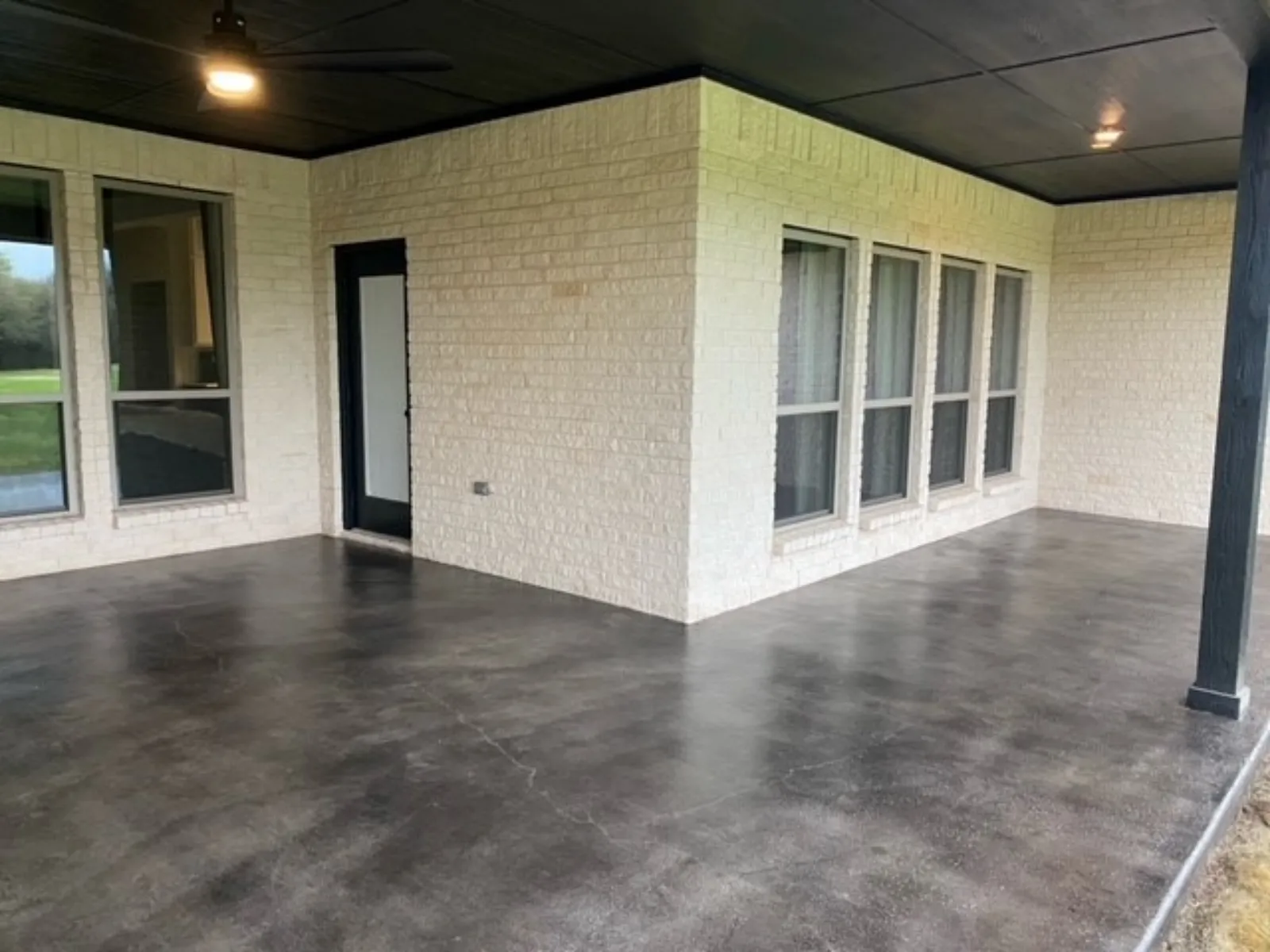 Finished covered smoth concrete patio with variegated Black Antiquing Stain and a sealed satin-like sheen.