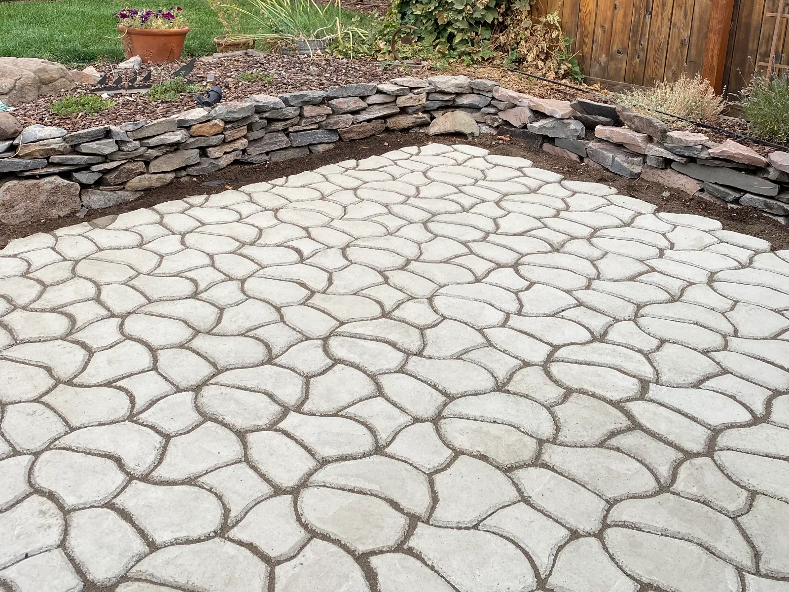 Unstained cobblestone-pattern concrete patio before applying Cafe Royale, Olive, and Charcoal Antiquing Stain.